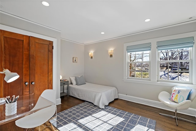 bedroom with ornamental molding and dark hardwood / wood-style flooring