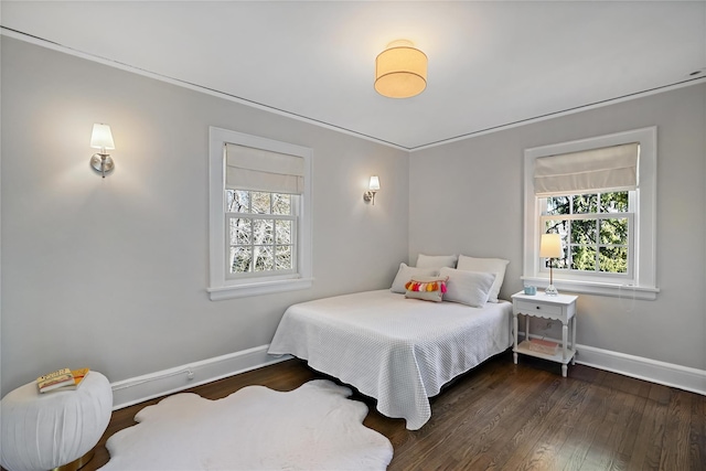 bedroom with multiple windows, ornamental molding, and dark hardwood / wood-style floors