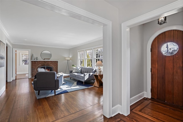 entryway featuring a fireplace, ornamental molding, and dark hardwood / wood-style floors