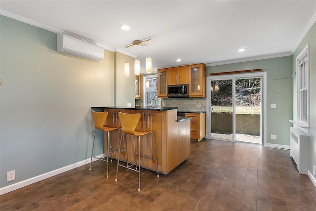 kitchen with hanging light fixtures, sink, kitchen peninsula, a wall unit AC, and a breakfast bar area