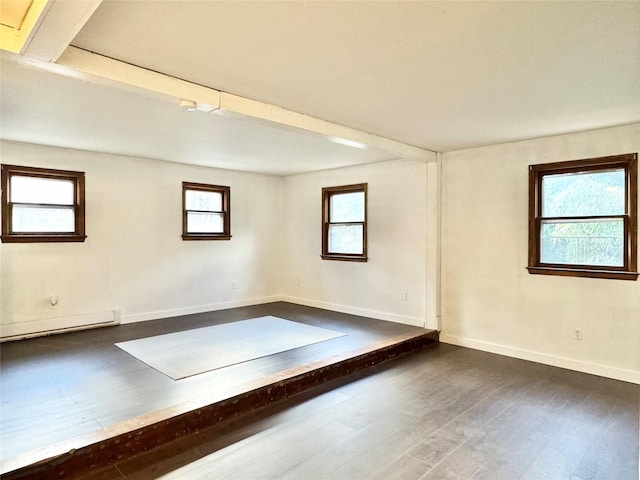 basement with dark hardwood / wood-style flooring and baseboard heating