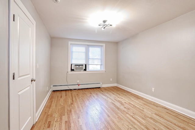 unfurnished room with baseboard heating, cooling unit, and light wood-type flooring