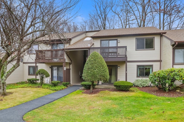 townhome / multi-family property featuring a balcony and a front yard