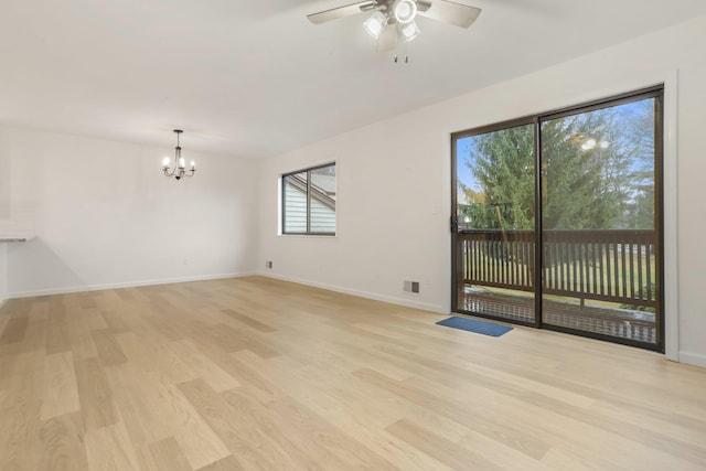 unfurnished room featuring ceiling fan with notable chandelier and light hardwood / wood-style floors