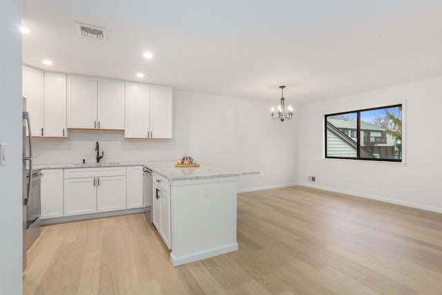 kitchen with white cabinetry, sink, and light wood-type flooring