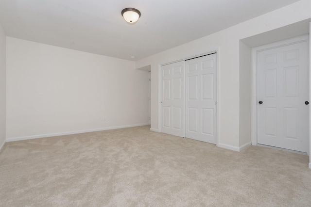 unfurnished bedroom with light carpet and a closet