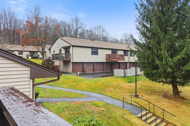 view of property exterior with a yard, a balcony, and a garage