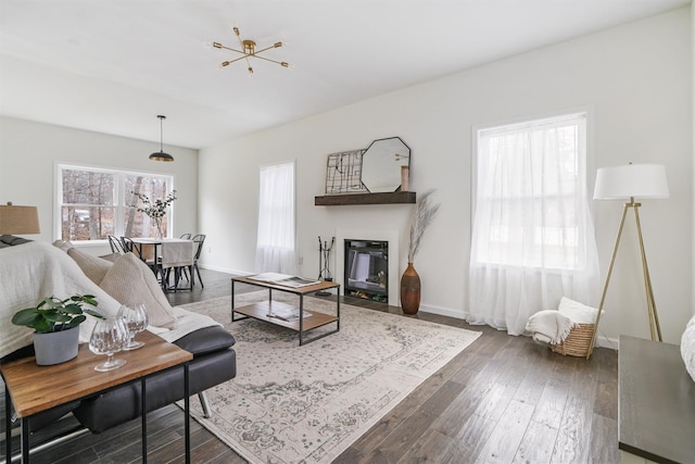 living room with a notable chandelier and dark hardwood / wood-style flooring