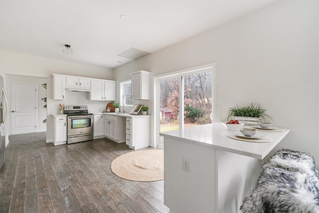 kitchen featuring stainless steel electric range, dark wood-type flooring, sink, kitchen peninsula, and white cabinetry