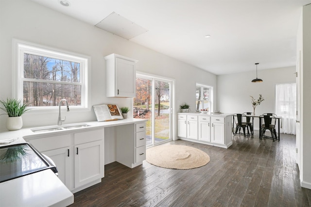 kitchen with dark hardwood / wood-style flooring, sink, white cabinets, and pendant lighting