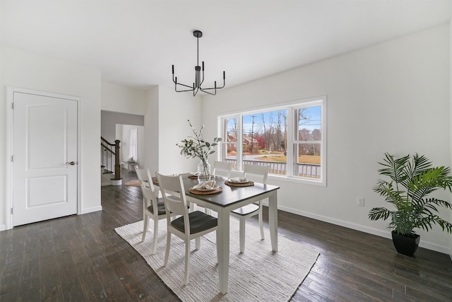 dining space featuring dark hardwood / wood-style flooring and an inviting chandelier