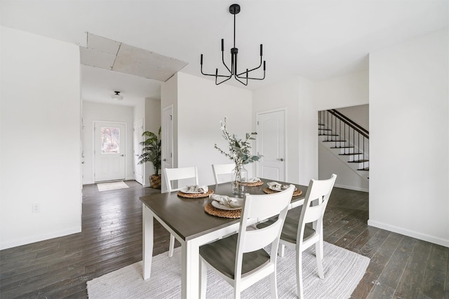 dining room with dark hardwood / wood-style flooring and an inviting chandelier