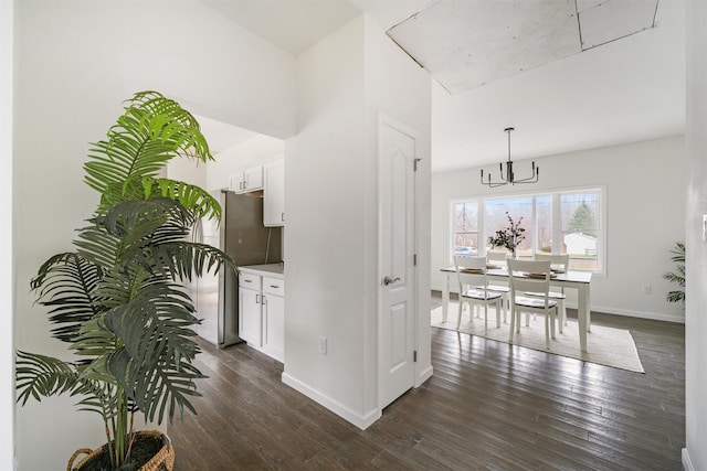 kitchen featuring pendant lighting, an inviting chandelier, white cabinetry, and dark wood-type flooring