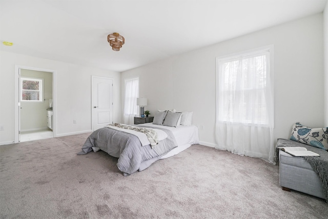 bedroom featuring light carpet and ensuite bath