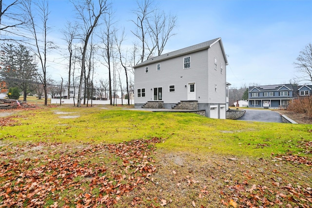 rear view of property with a lawn and a garage