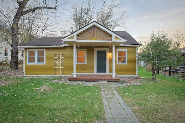 bungalow-style home with covered porch and a front yard