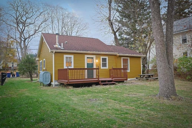 back of property with a lawn and a wooden deck