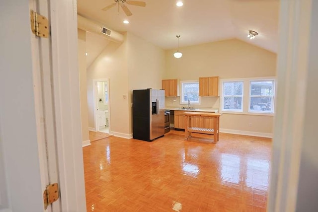 kitchen featuring ceiling fan, sink, decorative light fixtures, light brown cabinetry, and appliances with stainless steel finishes