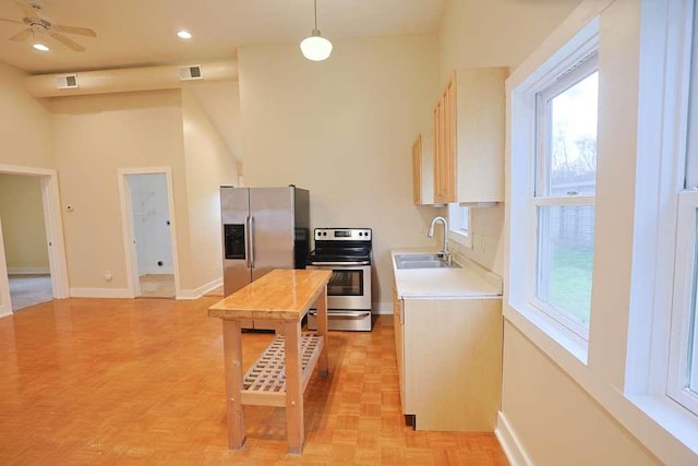 kitchen featuring appliances with stainless steel finishes, ceiling fan, sink, decorative light fixtures, and light parquet flooring