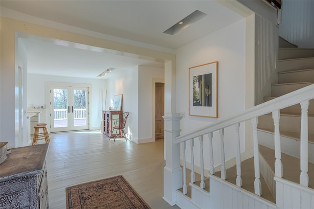 staircase featuring hardwood / wood-style flooring and french doors