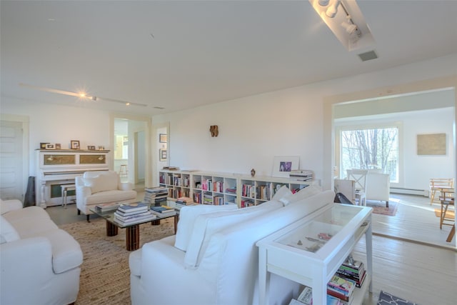 living room featuring a baseboard radiator and light hardwood / wood-style flooring