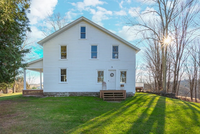 rear view of property featuring a lawn