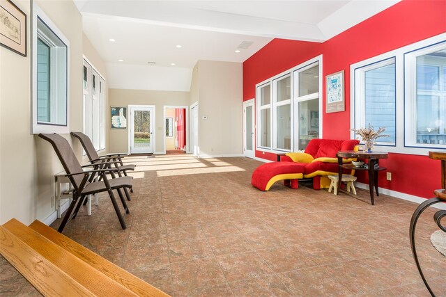 living area featuring vaulted ceiling with beams