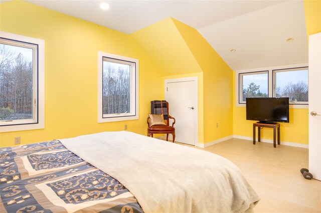 bedroom featuring light tile patterned floors, vaulted ceiling, and multiple windows