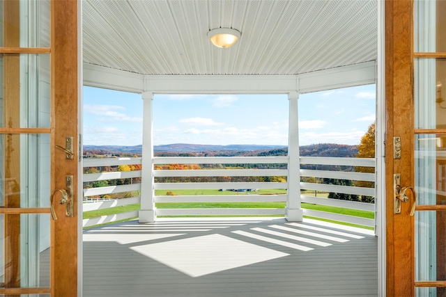 unfurnished sunroom featuring a water and mountain view