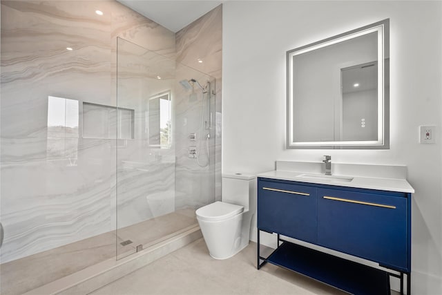 bathroom with a tile shower, vanity, and toilet