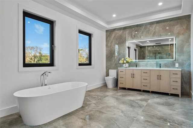 full bathroom featuring vanity, a raised ceiling, separate shower and tub, tile walls, and toilet