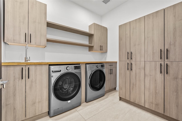 laundry room with cabinets, separate washer and dryer, and sink