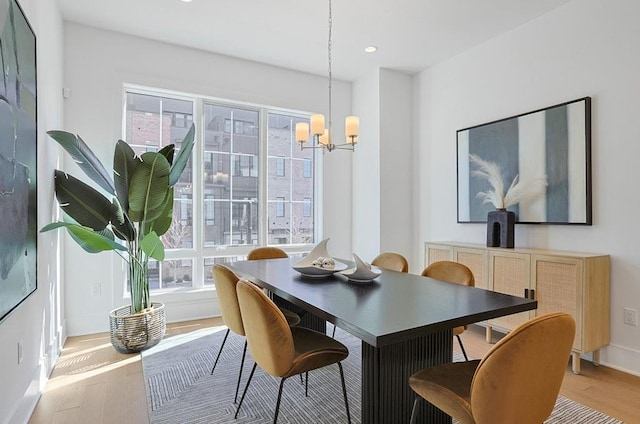 dining room with light wood finished floors, recessed lighting, and an inviting chandelier