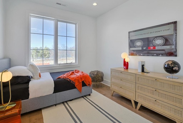 bedroom featuring baseboards, wood finished floors, visible vents, and recessed lighting