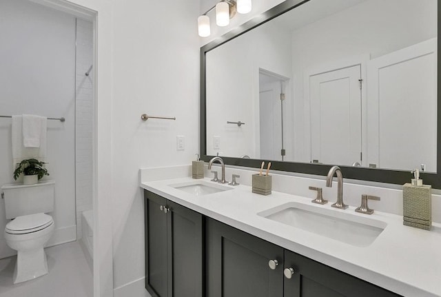 bathroom with  shower combination, double vanity, a sink, and toilet