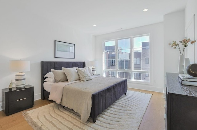 bedroom featuring light wood finished floors, baseboards, and recessed lighting