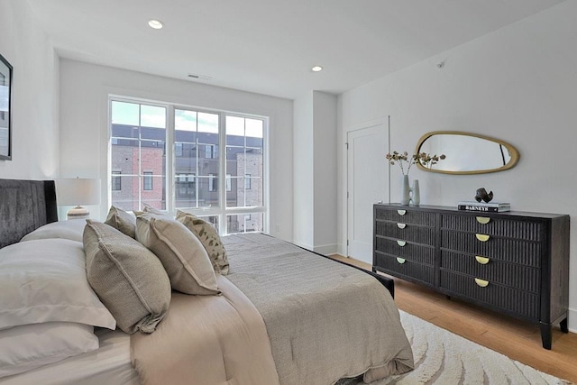 bedroom with light wood-style flooring, visible vents, baseboards, and recessed lighting