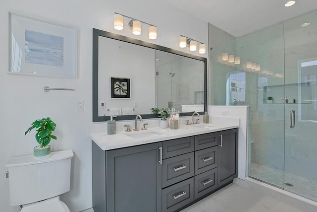 bathroom featuring marble finish floor, double vanity, a stall shower, and a sink