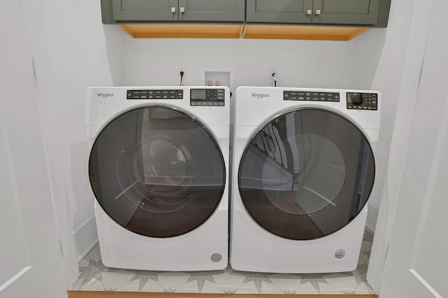 laundry room featuring washing machine and clothes dryer and cabinet space