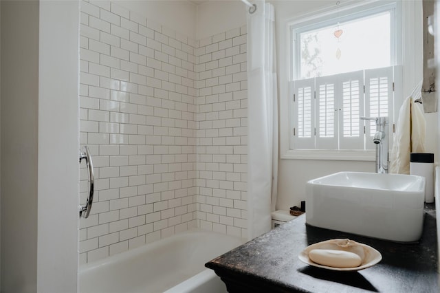 bathroom with shower / bathtub combination with curtain and sink