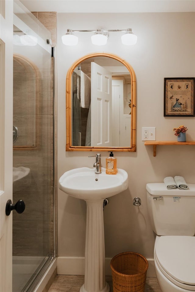 bathroom with tile patterned flooring, toilet, and a shower with shower door