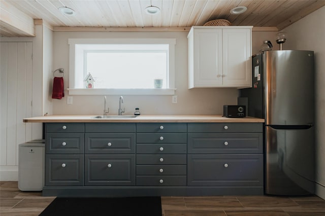 kitchen featuring wood ceiling, sink, white cabinetry, gray cabinets, and stainless steel refrigerator