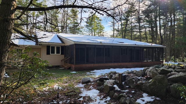 snow covered property with a sunroom