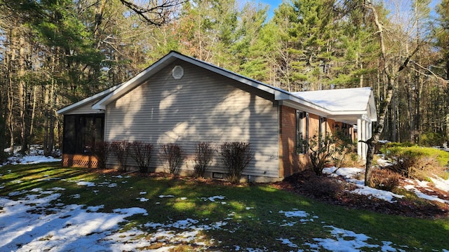 view of property exterior with a sunroom and a lawn