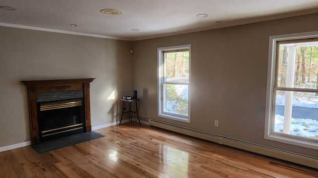 unfurnished living room with a healthy amount of sunlight, light hardwood / wood-style floors, ornamental molding, and a baseboard radiator