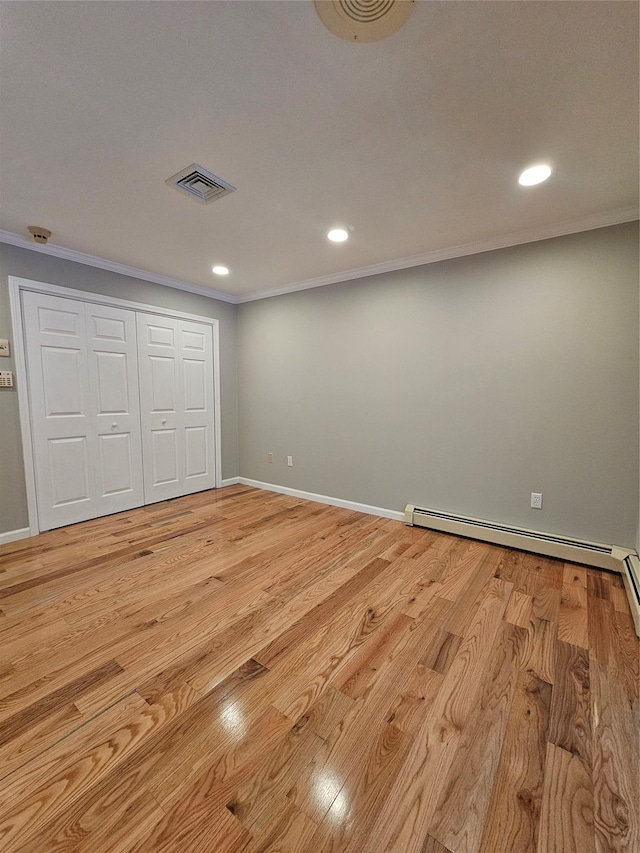 spare room featuring wood walls and a baseboard radiator