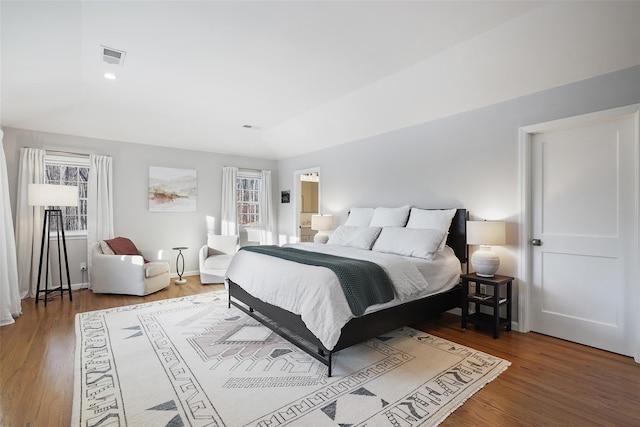 bedroom featuring wood finished floors and visible vents