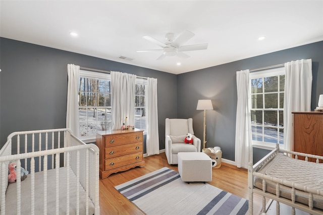 bedroom featuring light wood-style floors, multiple windows, and baseboards