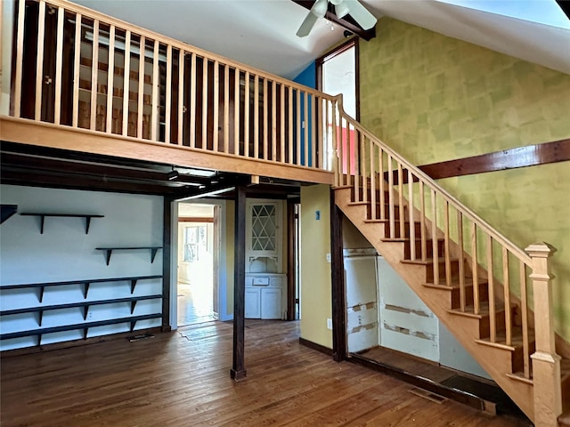 stairway featuring wood-type flooring, high vaulted ceiling, and ceiling fan