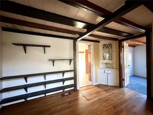 interior space with beamed ceiling, hardwood / wood-style floors, and wood ceiling